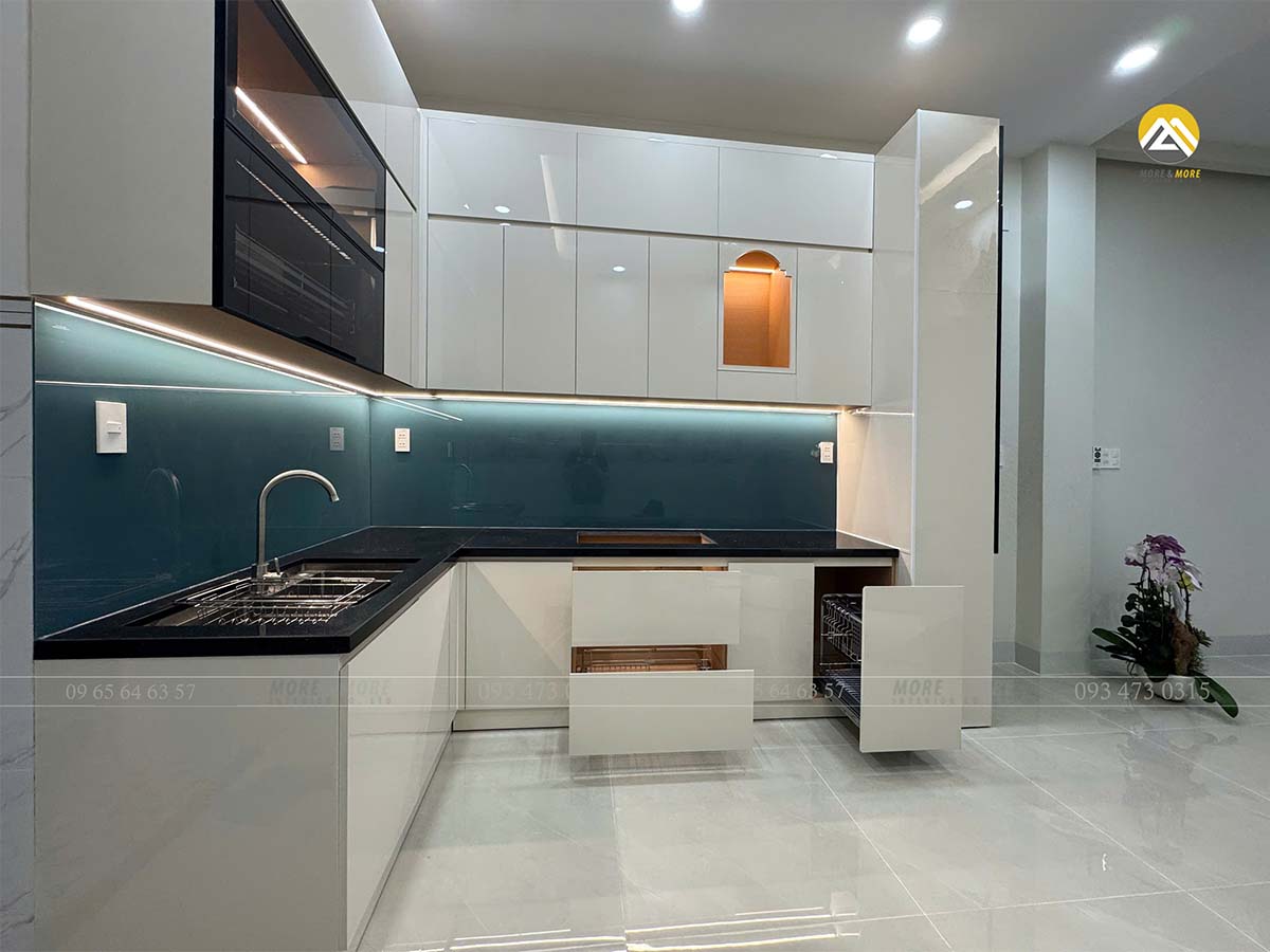 Tủ bếp sử dụng acrylic màu trắng kem gỗ An Cường kết hợp cánh hợp kim nhôm lồng kính màu trà